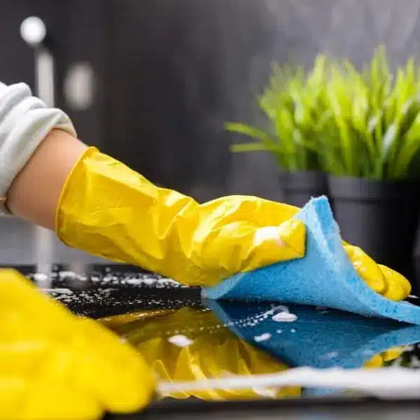 Cleaning-03-ezgif.com-optiwebp gloved hands cleaning a counter with a blue sponge